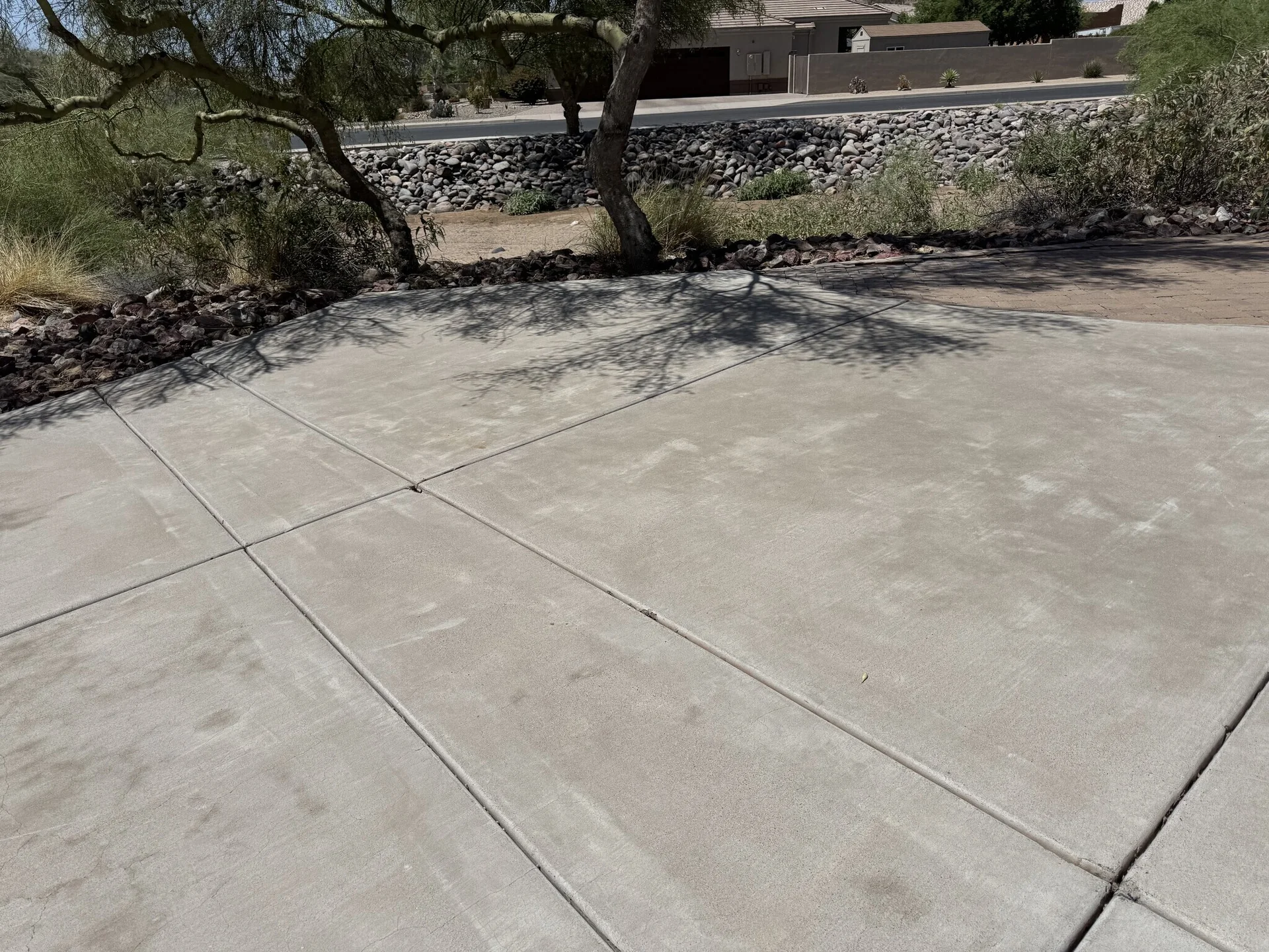 Pressure washing mist drifting across Arizona property at sunset