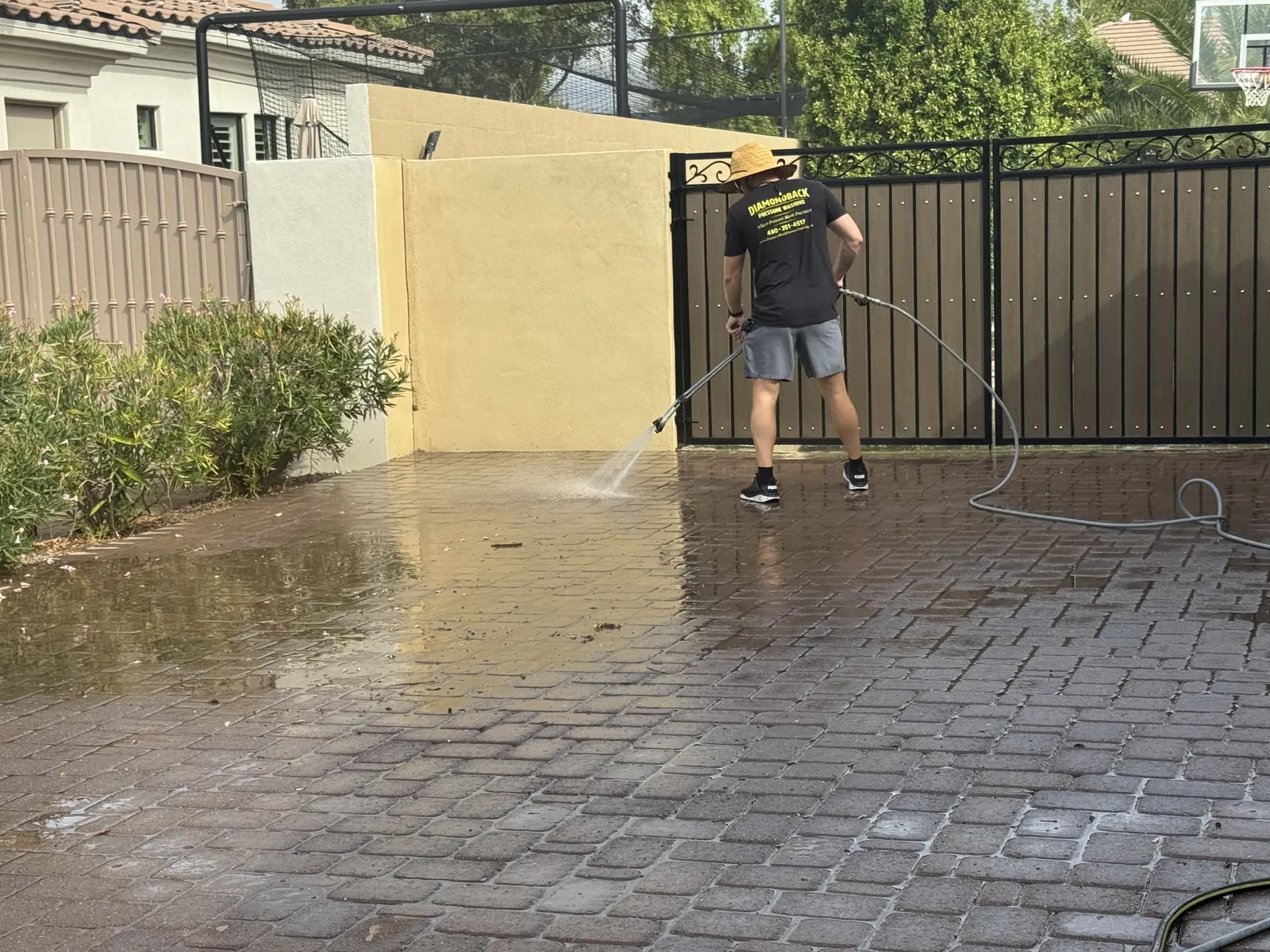 Brown runoff and debris being flushed off a brick paver courtyard during pressure washing
