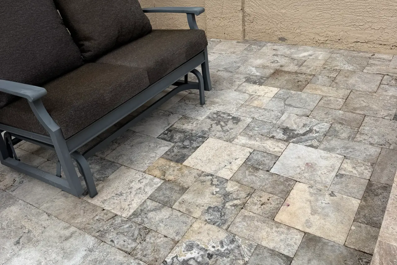 Clean travertine patio with firepit and seating after professional cleaning