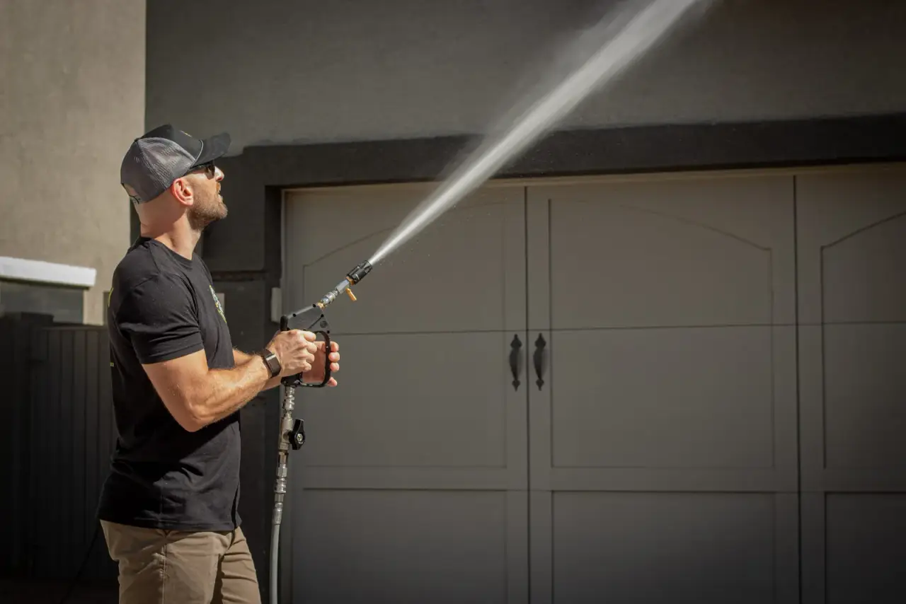 Diamondback technician soft washing a Gilbert AZ home exterior and garage