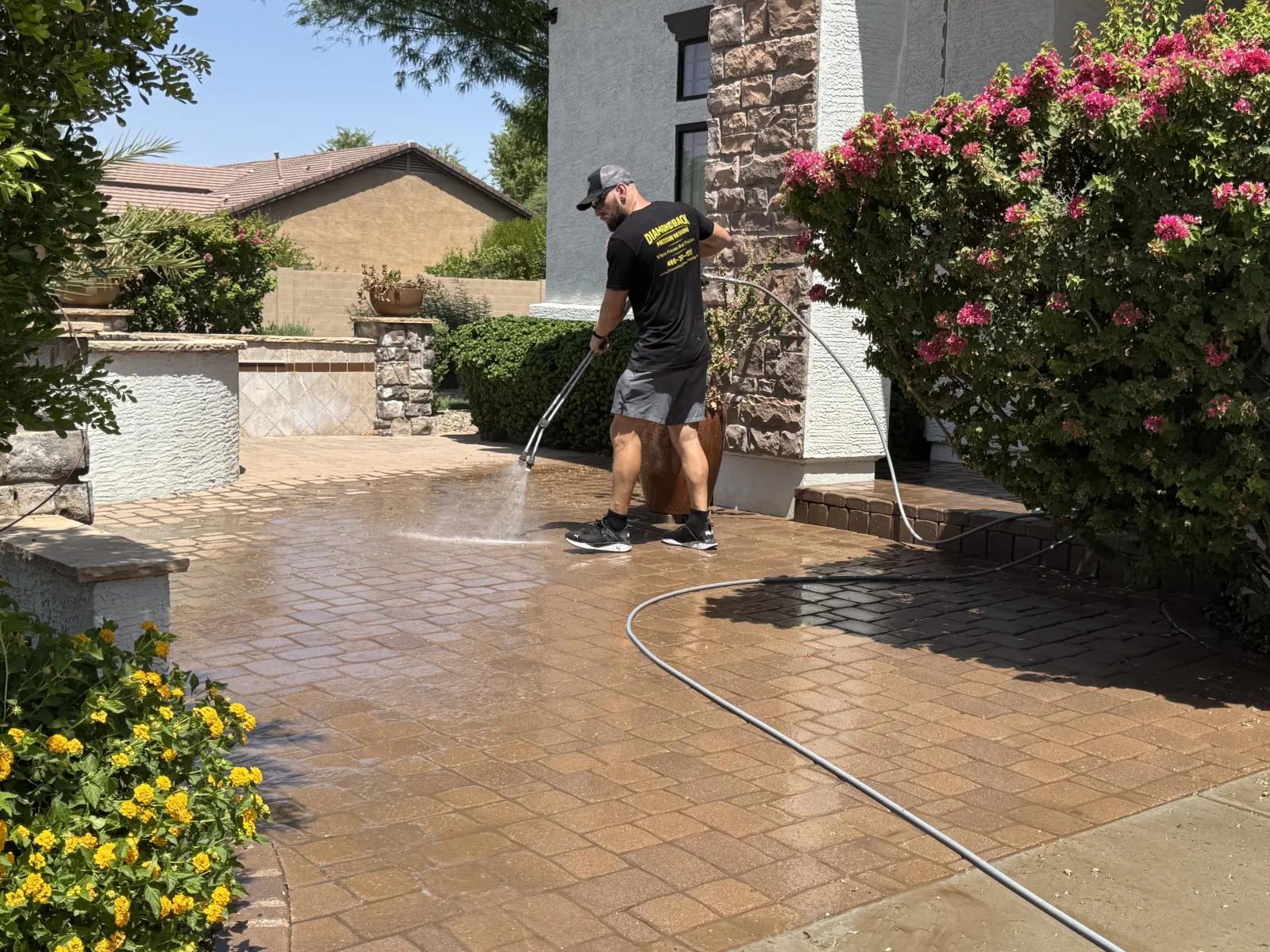 Diamondback technician washing a paver patio entry in the East Valley