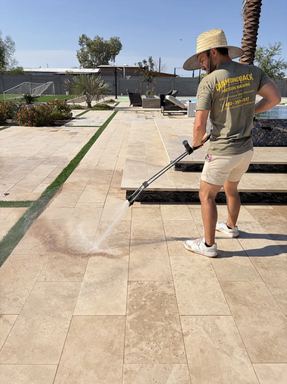 Diamondback technician cleaning a travertine patio in Gilbert, Arizona before sealing