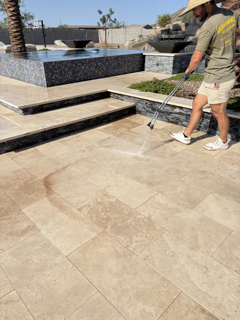 Pressure washing a travertine pool deck before sealing in Gilbert, Arizona